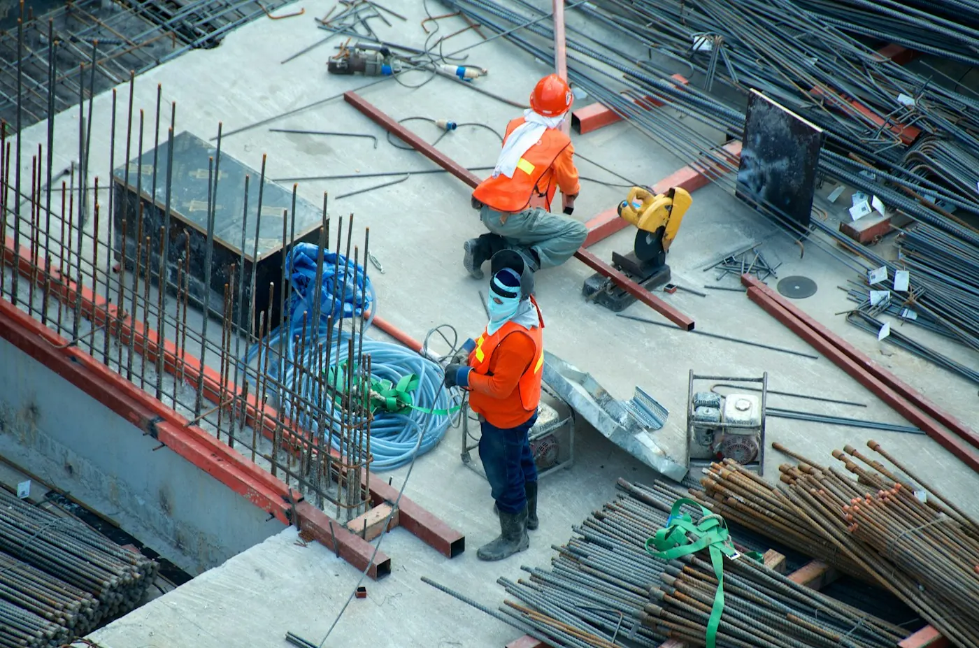 Construction workers coordinating steel and services on an active build