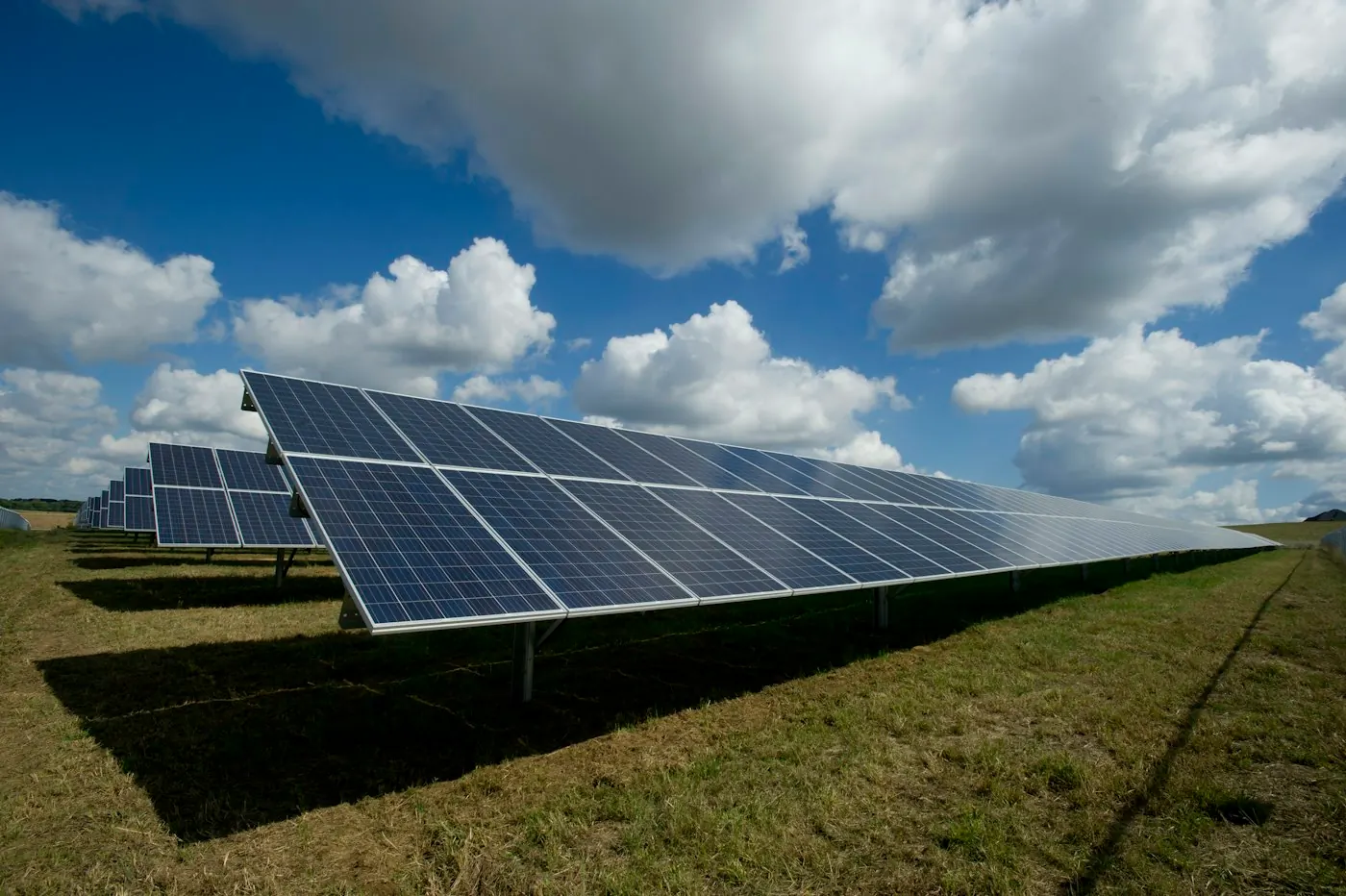 Rows of solar photovoltaic panels beneath a bright open sky